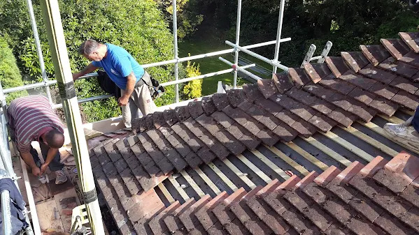 Roof tiles being relaid by the MJS team