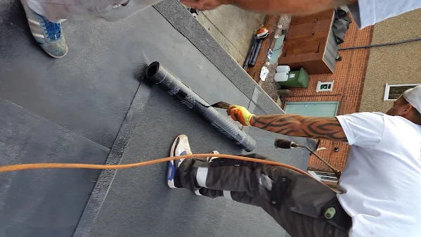 MJS roofer installing a flat-roof membrane